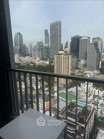 Stunning cityscape view from a high-rise balcony overlooking modern skyscrapers and urban landscape.
