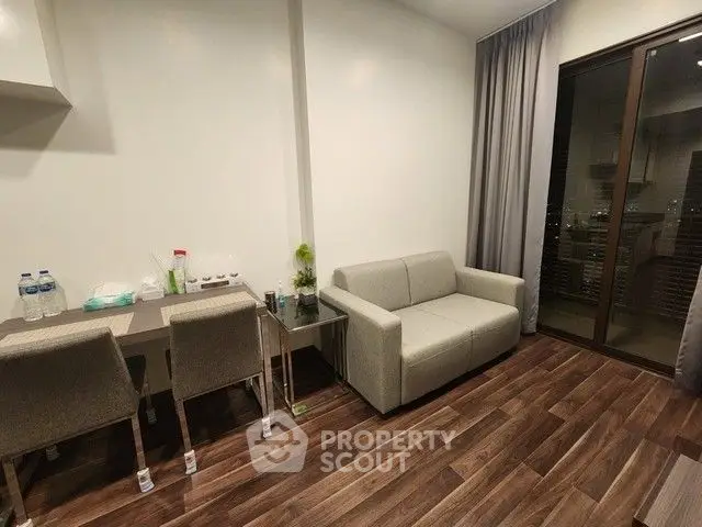 Modern living room with sleek furniture and wooden flooring, featuring a cozy sofa and dining area.