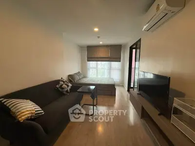 Modern living room with cozy sofa, TV, and large window in stylish apartment.