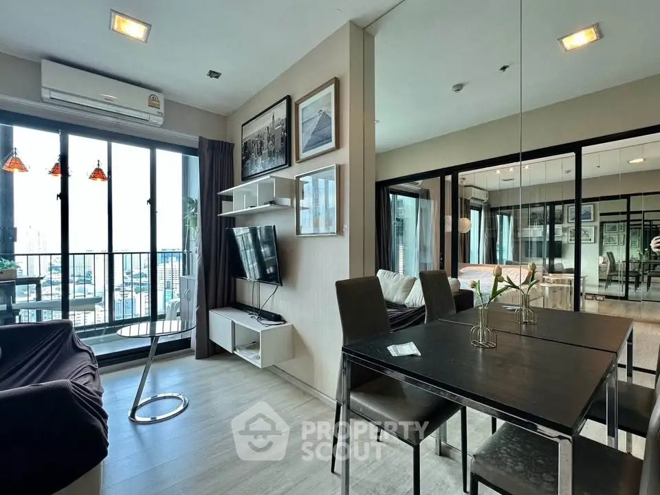Modern living room with balcony view, stylish decor, and dining area in a high-rise apartment.