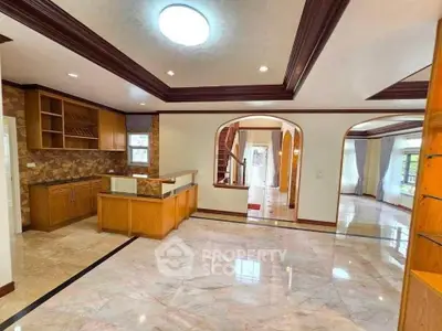 Spacious open-plan living area with elegant wooden finishes and marble flooring.
