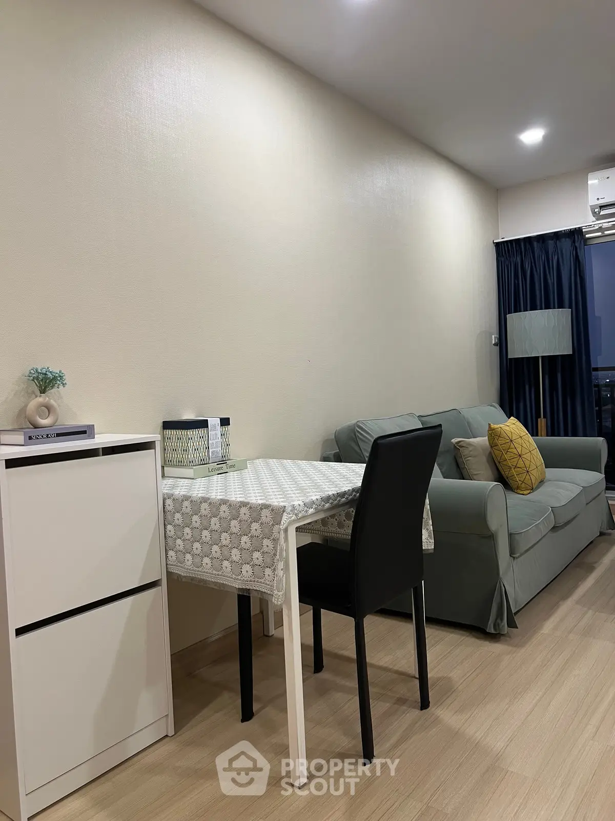 Cozy living room with modern furniture and dining area in a stylish apartment.