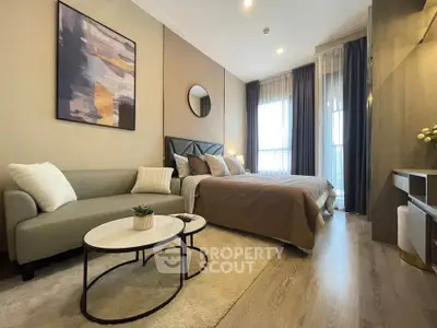 Modern bedroom with stylish decor, cozy seating area, and natural light from large windows.