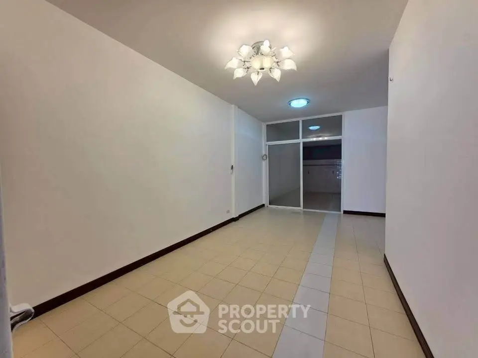 Spacious empty room with tiled floor and modern ceiling light