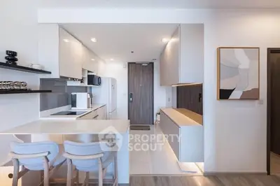Modern kitchen with sleek design, featuring open layout and stylish seating in a contemporary apartment.