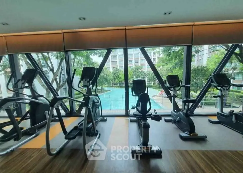 Modern gym with pool view in luxury residential complex