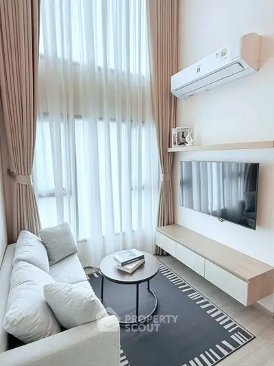 Modern living room with high ceilings, large windows, and stylish decor