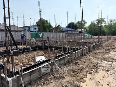 Construction site with foundation work and steel reinforcements for new building development.