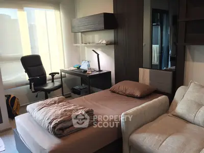 Modern bedroom with workspace, featuring a cozy bed, desk, and office chair, ideal for urban living.