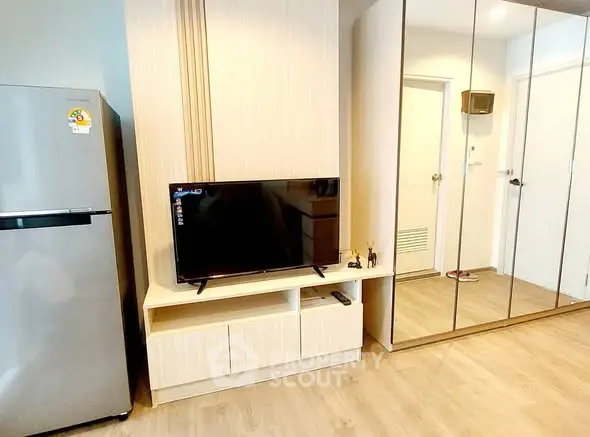 Modern living area with sleek TV stand and mirrored wardrobe