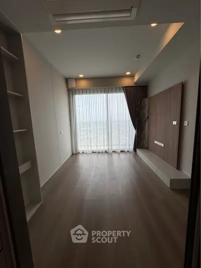 Spacious modern living room with floor-to-ceiling windows and elegant wood flooring.
