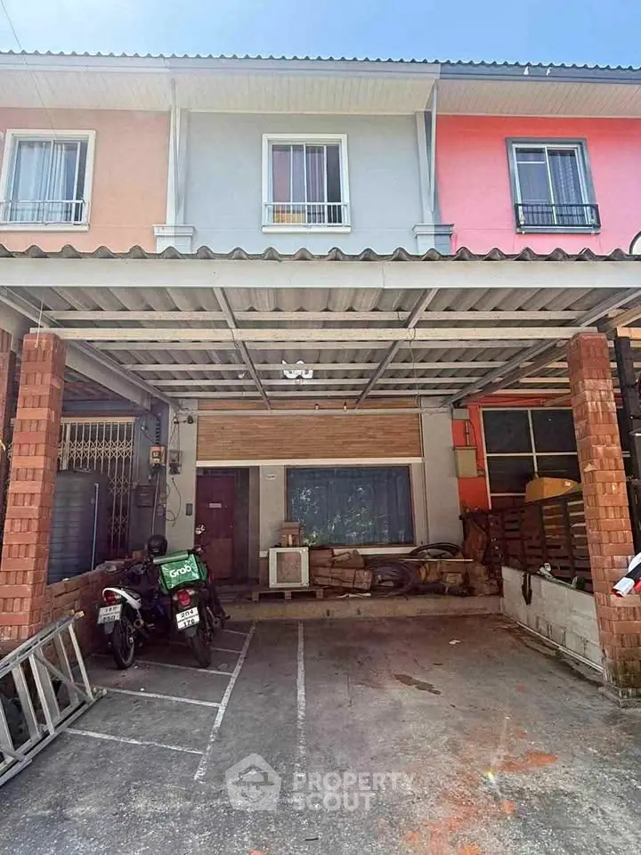 Charming townhouse with covered parking and vibrant facade, perfect for modern living.