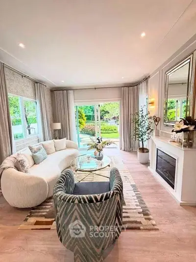 Elegant living room with stylish furniture and large windows overlooking a lush garden.
