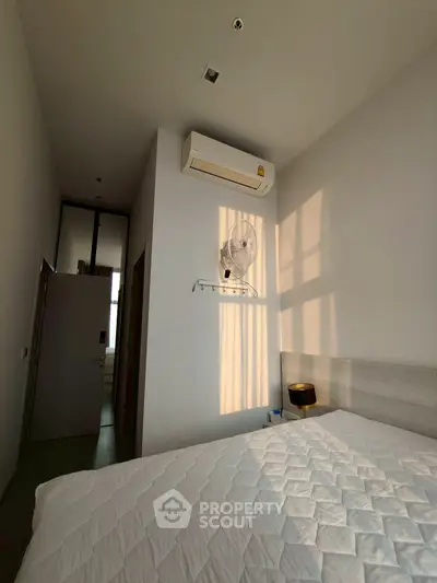 Cozy bedroom with natural light and air conditioning, perfect for relaxation.