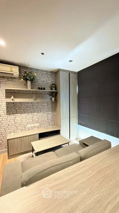 Modern living room with stylish brick wall and cozy furniture in a contemporary apartment.