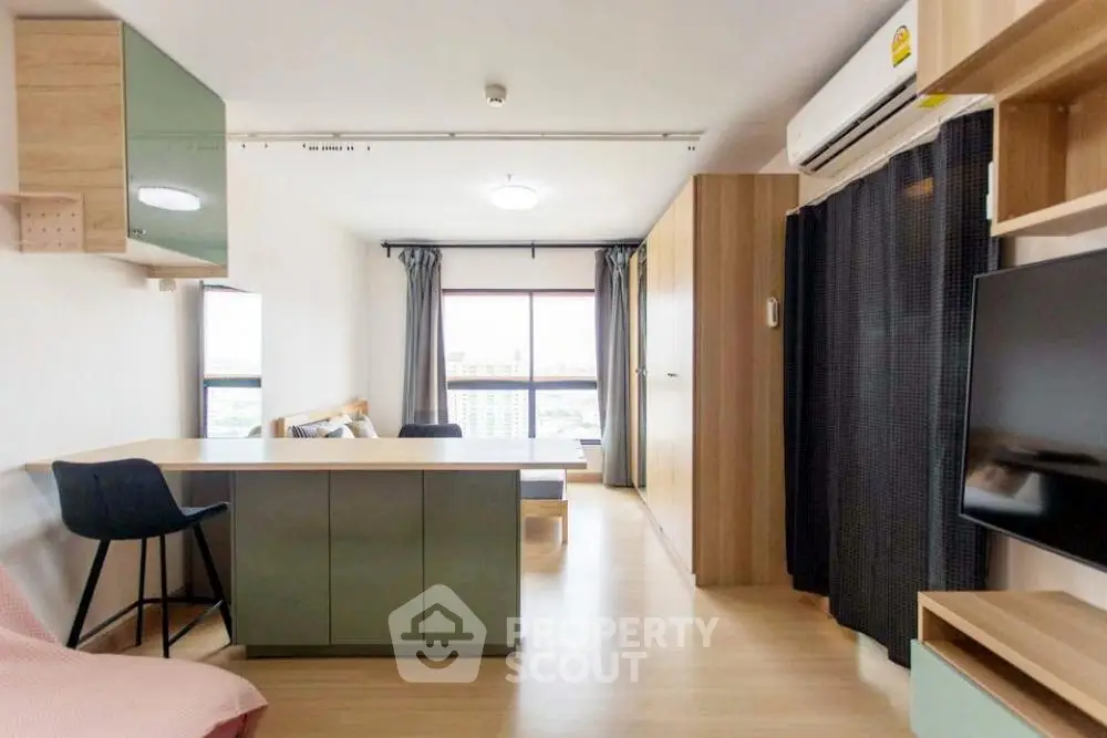 Modern studio apartment with open layout and large window view.