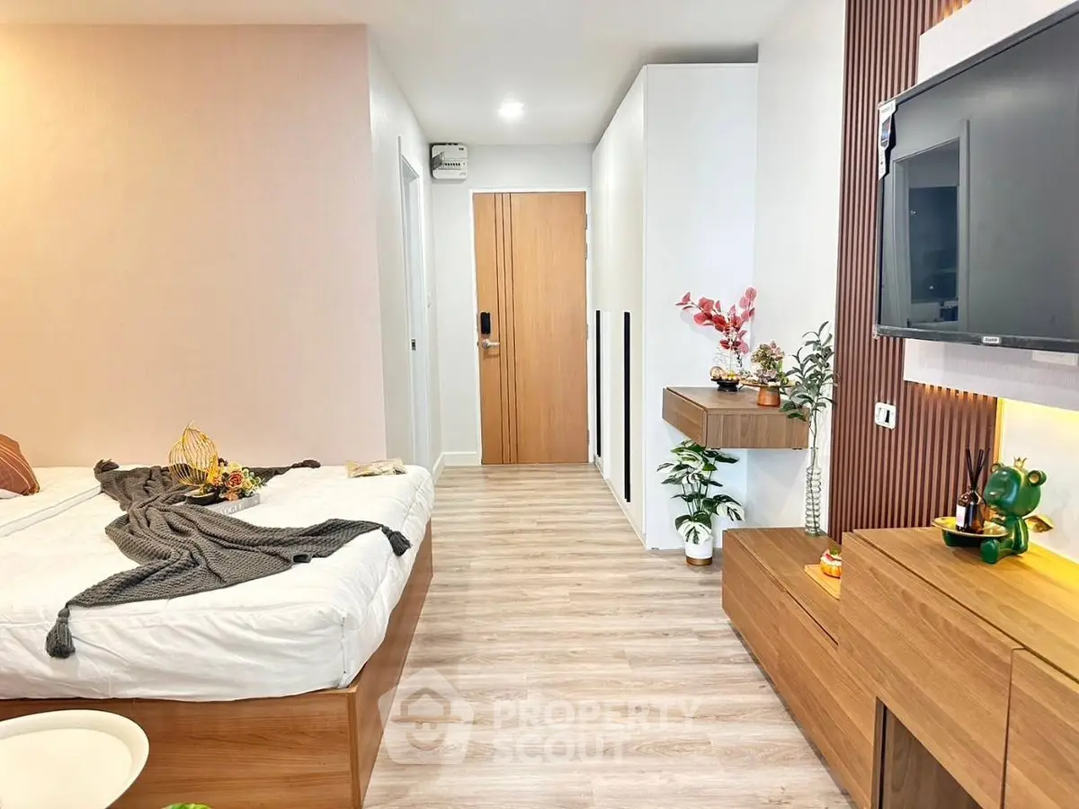 Modern bedroom with stylish decor and wall-mounted TV