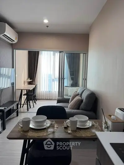 Modern living room with cozy seating and dining area, featuring natural light and stylish decor.