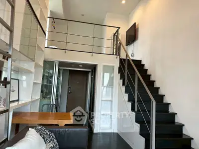 Modern loft apartment with mezzanine, sleek staircase, and open living area.