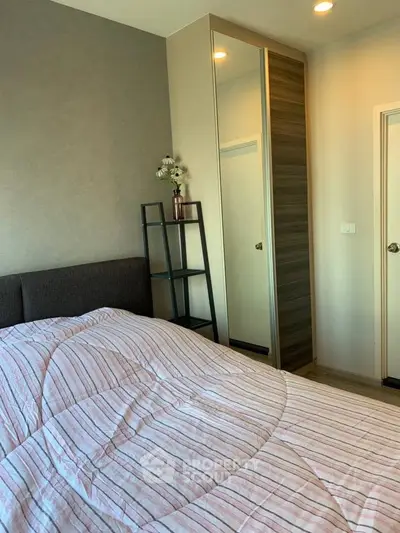 Modern bedroom with stylish decor and ample natural light, featuring a cozy bed and sleek storage solutions.