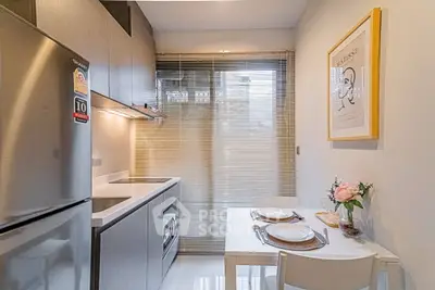 Modern kitchen with sleek cabinetry and cozy dining area, perfect for urban living.
