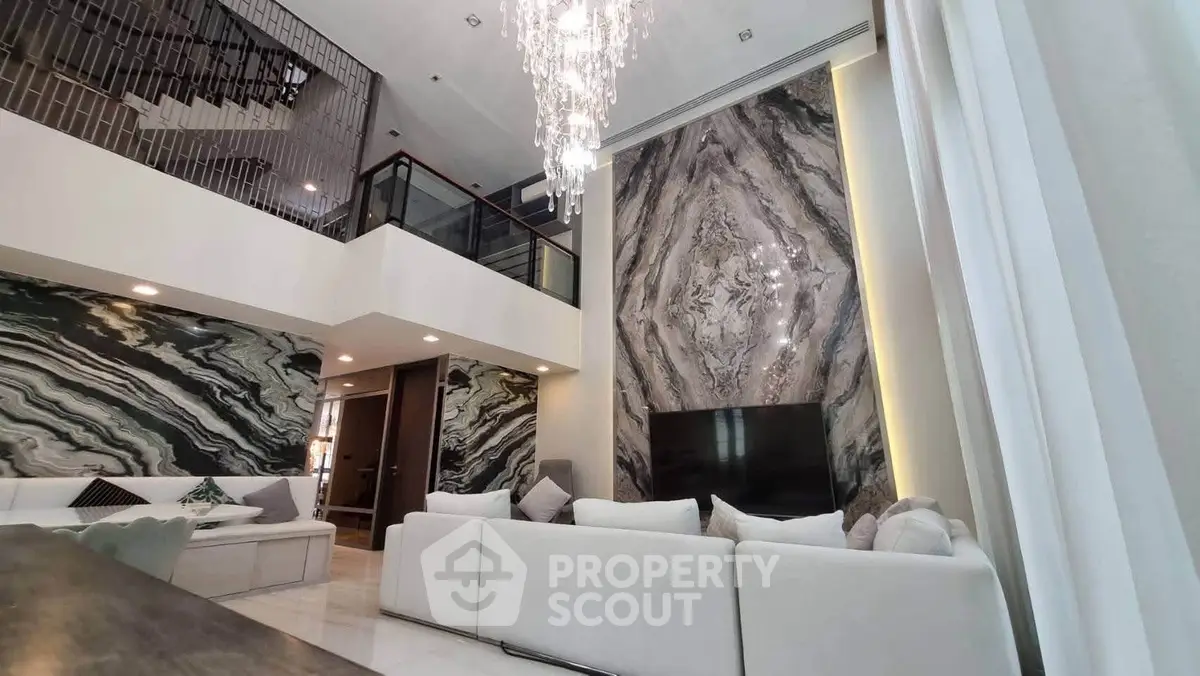 Luxurious modern living room with high ceilings and elegant chandelier
