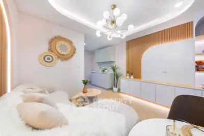 Modern living room with stylish decor and open kitchen layout, featuring elegant lighting and cozy seating.