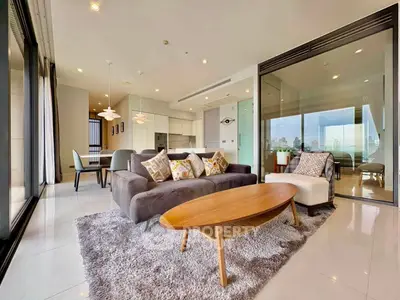 Spacious modern living room with open kitchen and city view, featuring stylish furniture and elegant decor.