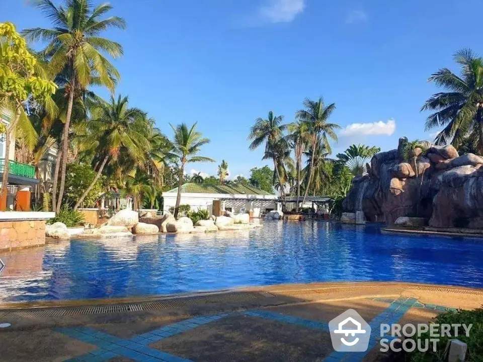 Luxurious tropical resort pool with palm trees and clear blue sky