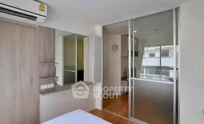 Modern bedroom with sliding glass door and air conditioning in a stylish apartment.