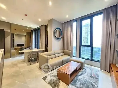 Modern living room with large windows and stylish furniture in a high-rise apartment.