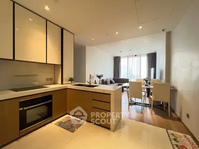 Modern open-plan kitchen and living room with stylish decor and natural light.