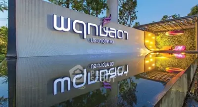 Modern building entrance with reflective water feature and illuminated signage.