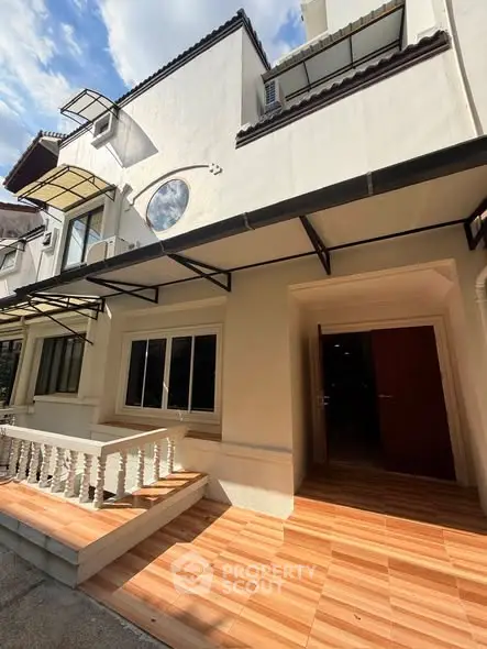 Charming townhouse exterior with tiled patio and elegant architectural details.