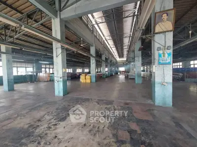 Spacious industrial warehouse with high ceilings and ample natural light.