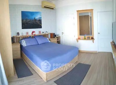 Spacious bedroom with modern decor and wooden flooring, featuring a cozy bed and stylish wall art.