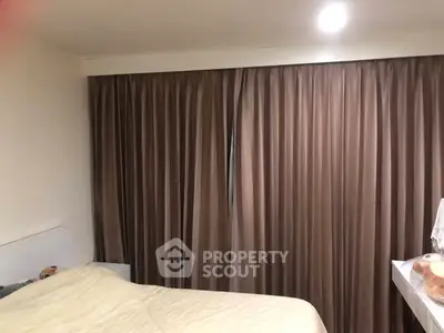 Cozy bedroom with elegant curtains and soft lighting, perfect for relaxation.