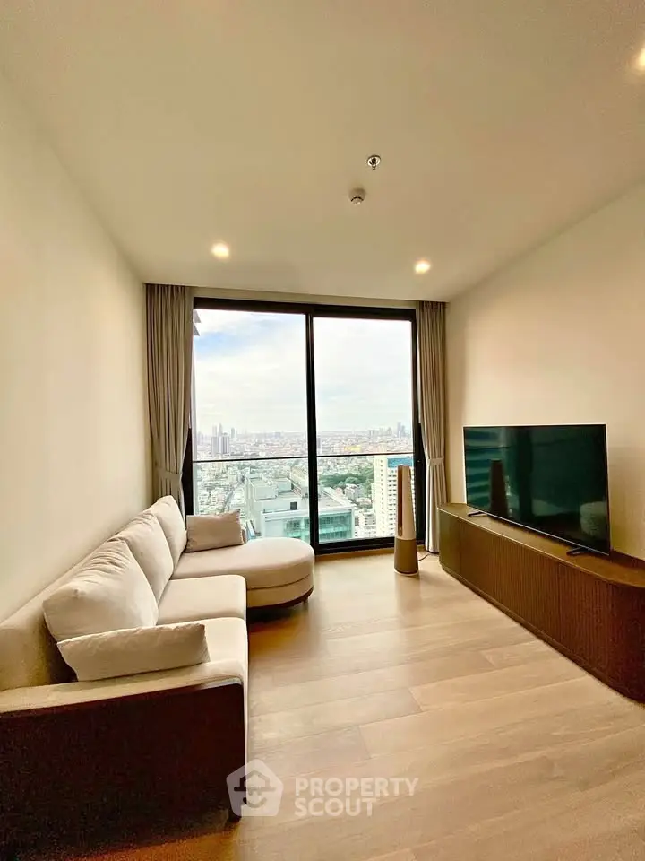 Modern living room with panoramic city view, featuring sleek furniture and large windows.