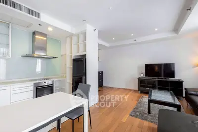 Modern open-plan living room with sleek kitchen and hardwood floors