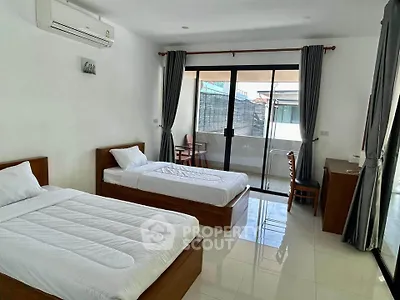 Spacious twin bedroom with balcony access and modern furnishings
