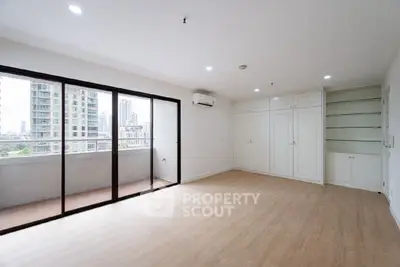 Spacious modern living room with balcony and city view, perfect for urban living.