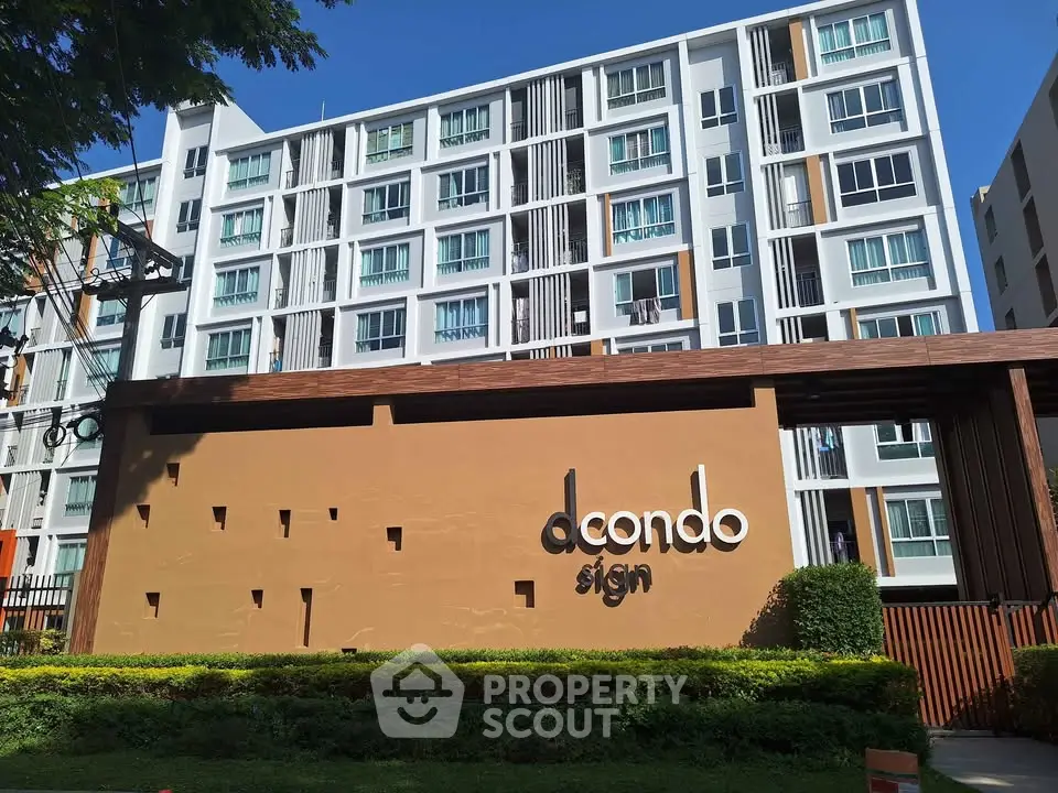 Modern condominium building with stylish facade and lush greenery in urban setting.
