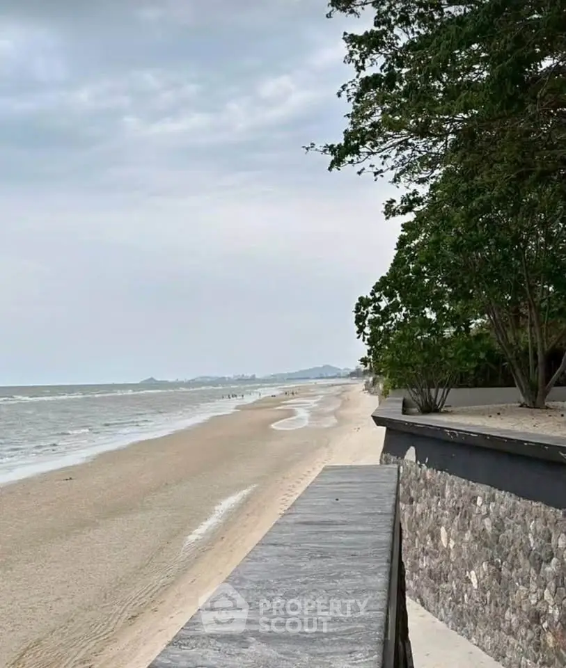 Stunning beachfront view with sandy shores and lush greenery, perfect for serene living.