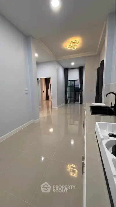 Spacious modern apartment interior with sleek kitchen and elegant lighting.