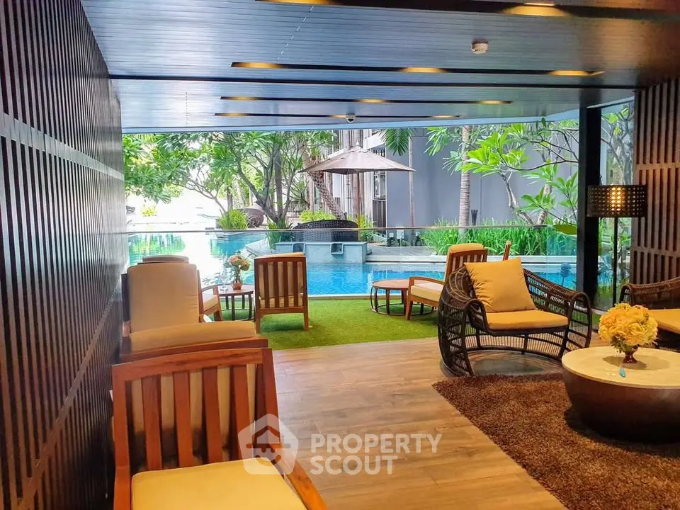 Luxurious poolside lounge with elegant seating and lush greenery, perfect for relaxation and leisure.