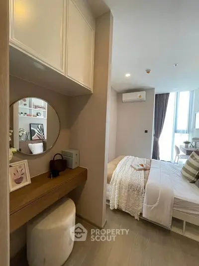 Modern bedroom with stylish decor and cozy ambiance, featuring a dressing table and large window for natural light.