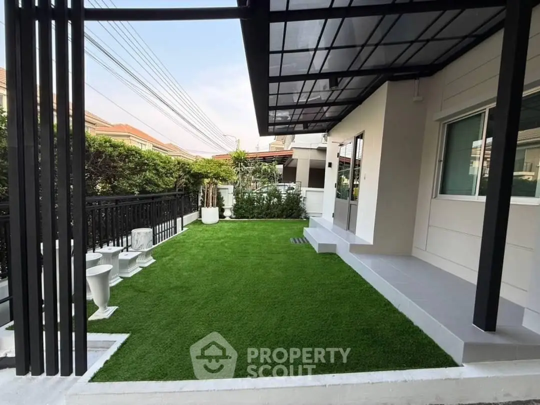 Modern home exterior with lush green lawn and sleek patio design