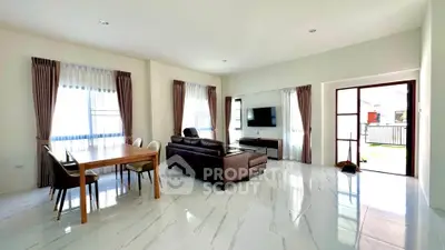 Spacious modern living room with elegant dining area and natural light.