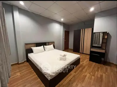 Spacious bedroom with modern furnishings and wooden flooring, ideal for comfort and relaxation.