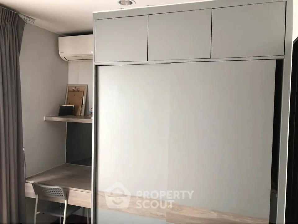 Modern study area with built-in desk and storage in a stylish apartment.